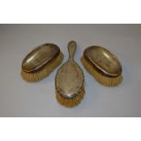 A three piece H/M silver dressing table set