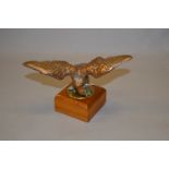 A phosphor bronze car mascot in the form of an eagle set on a brass base.