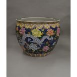 A large Chinese porcelain fish bowl of ovoid form with painted five-claw dragon amongst foliage