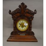 A Victorian wooden cased chiming mantle clock with key and pendulum.