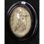 A 19th century carved wall plaque in oval frame depicting a religious scene