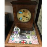 An early 20th century wooden cased Mantle clock and a tray with a sampler under glass in base.