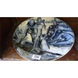 A studio pottery charger decorated with naked ethnic ladies washing clothes by a river, monogram