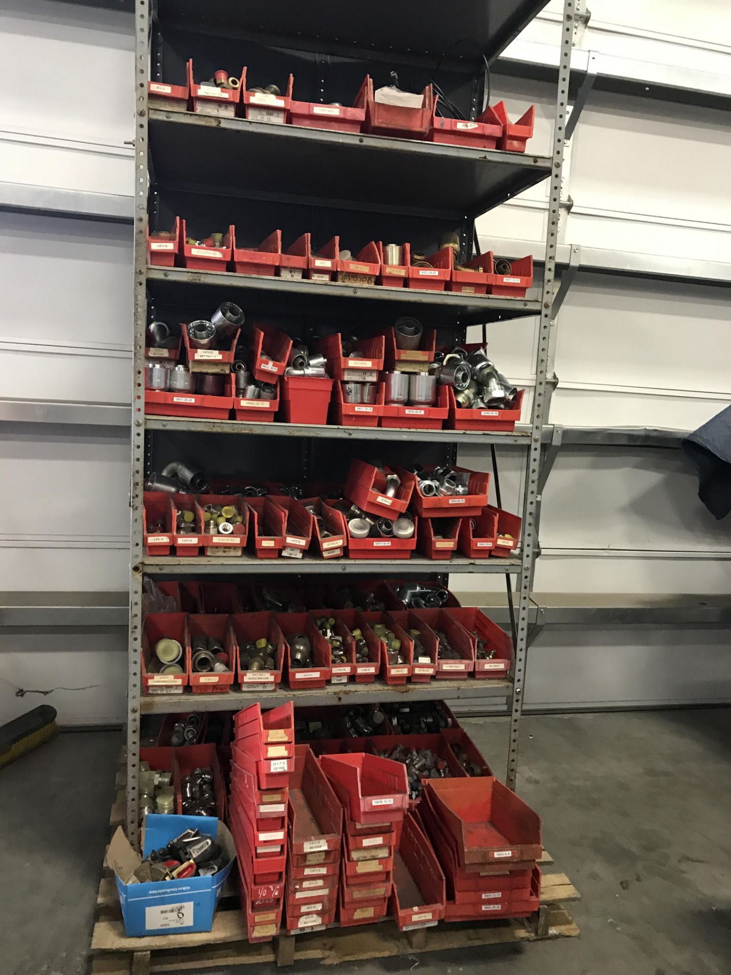 HUNDREDS OF NEW ASSORTED HYDRAULIC FITTINGS ON STEEL SHELF.