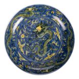 A Chinese blue and yellow glazed dish, decorated with dragons and flaming pearls, with a Qianlong