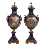 A pair of impressive ornamental vases in Sèvres with gold-layered blue royale ground, decorated with