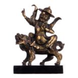 A Chinese polychrome and gilt bronze sculpture depicting a divinity on a mythical animal, on a