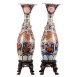 A pair of Japanese vases in polychrome decorated Arita, Meiji, with accompanying sculptured wooden