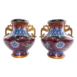 A pair of Chinese cloisonné vases, decorated with floral motifs and symbols, the ears dragon