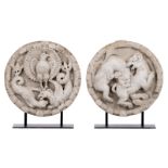 A pair of round Carrara marble bas reliefs depicting mythical creatures, in Romanesque style,
