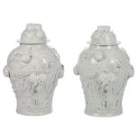 An exceptional pair of Chinese Blanc de Chine vases with covers, peaches relief decorated, with