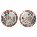 A fine pair of Chinese famille rose plates, decorated with dignitaries, warriors and sevants in a