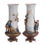 A pair of red stoneware vases, polychrome and partly cold painted relief decoration depicting