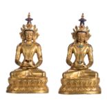 A pair of gilt bronze seated Buddhas, Sino-Tibetan, with glass and semi-precious stones inlay,