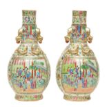 A pair of Chinese bottle vases, famille rose & relief decorated with scenes from court life,