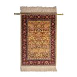 An Oriental silk rug with floral motifs, marked, with corresponding brass rod, 63 x 93 cm