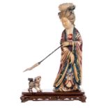 A Chinese polycrhome decorated ivory sculpure, depicting a court lady and a dog, on a wooden base,