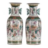 A pair of Chinese famille rose vases, overall decorated with a court scene on a terrace in a