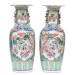 A pair of Chinese famille rose vases, decorated with a battle scene and a scene from court life, H