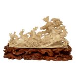 A Chinese ivory group depicting 'young heroes hunting for reindeers' on a carved wooden base,