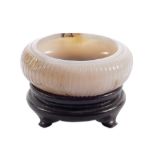A Chinese carved jade brush washer on a matching wooden base, H 4,8 (with base) - 3 cm (without