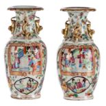 A pair of Chinese Canton famille rose vases, the roundels decorated with court scenes, relief