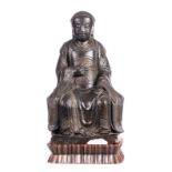A Chinese seated bronze Buddha on a wooden base, Ming dynasty, H 39,5 cm