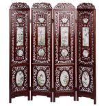 A Chinese quadripartite richly carved hardwood screen, with famille rose porcelain plaques,