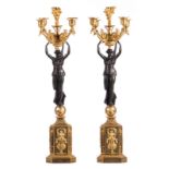 A pair of Neoclassical girandoles candlesticks in gilt and patinated bronze depicting winged