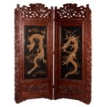 A Chinese richly carved wooden draught-screen with dragons, flower branches and birds, the pannels