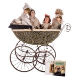 A doll carriage, about 1900, with five dolls in paper*maché, about 1960; added two books about