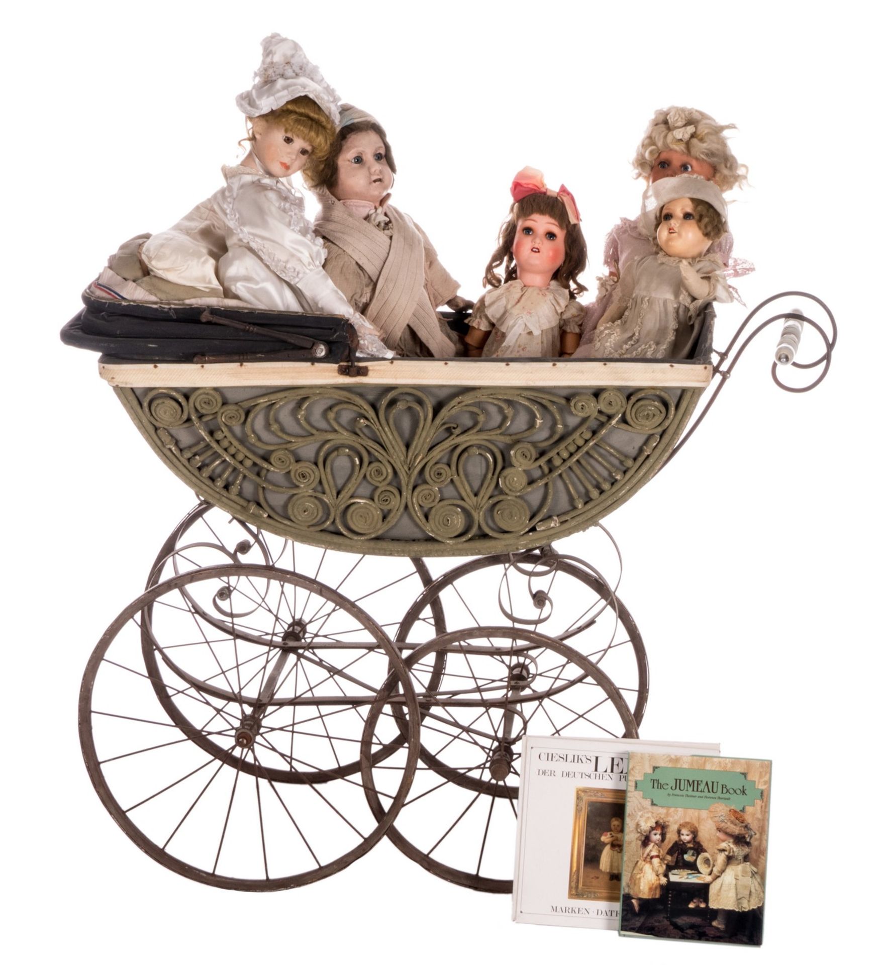A doll carriage, about 1900, with five dolls in paper*maché, about 1960; added two books about