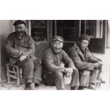 A Chinese black and white photograph of laughing labourers, signed Zhejiang, dated China 1987, 18,