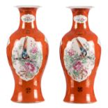 A pair of Chinese orange ground famille rose baluster shaped vases, the roundels with birds and