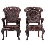 A pair of Japanese richly carved wooden armchairs, decorated with dragons and mythical birds, H 111-