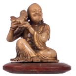 A Chinese gilt and polychrome decorated Shoushan stone Lohan Buddha, on a matching stone cushion,