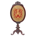 A mid 19thC rosewood heatscreen, the upholstering in gros point depicting the coat of arms of the