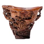 An extraordinary finely carved rhinoceros horn libation cup, the flaring sides finely carved in