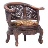 A richly carved and openworked phoenix and lotus flower decorated wooden oxbow armchair, H 81 cm