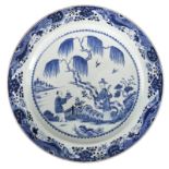 A Chinese blue and white decorated plate with a gallant scene in a mountainous river landscape,