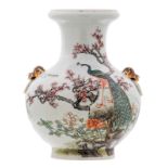 A Chinese famille rose baluster shaped vase, decorated with a peacock on a rock, flower branches and