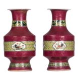 A pair of Chinese ruby ground baluster shaped vases, polychrome and relief decorated, the roundels