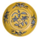 A Chinese yellow ground blue and white decorated dish with fruits and flower branches, with a