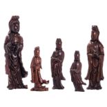 Five Chinese carved hardwood figures depicting a Guanyin, one figure with copper inlay, 19th -