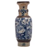 A Chinese blue and white and relief decorated stoneware vase with phoenix on a rock and flower