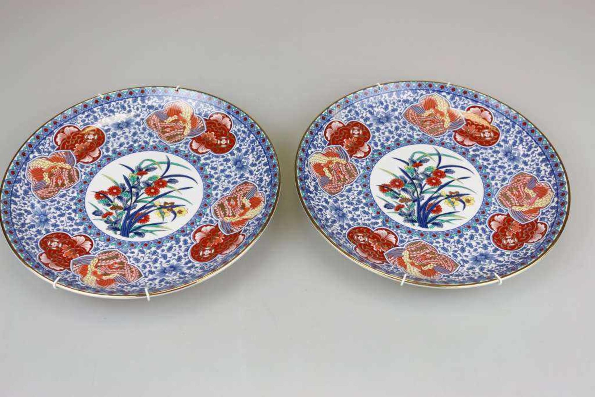 Paar Imari Teller, Japan, 20. Jh. Porzellan, polychrome Malerei mit Blumenspiegel. [...]