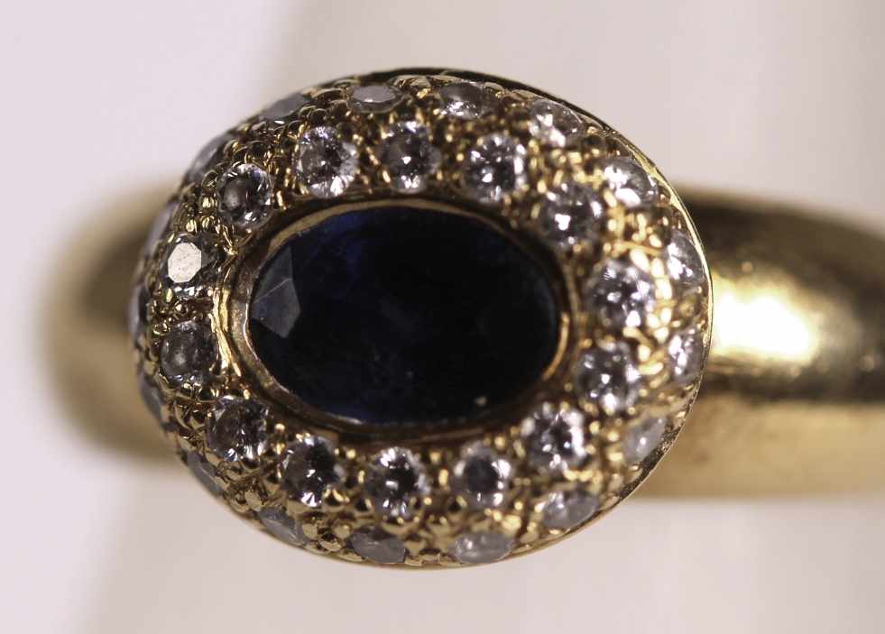 Damenring, GG 750, besetzt mit 1 Safir, ca. 0,90 ct., Farbe: dunkelblau, umgeben von Brillanten,