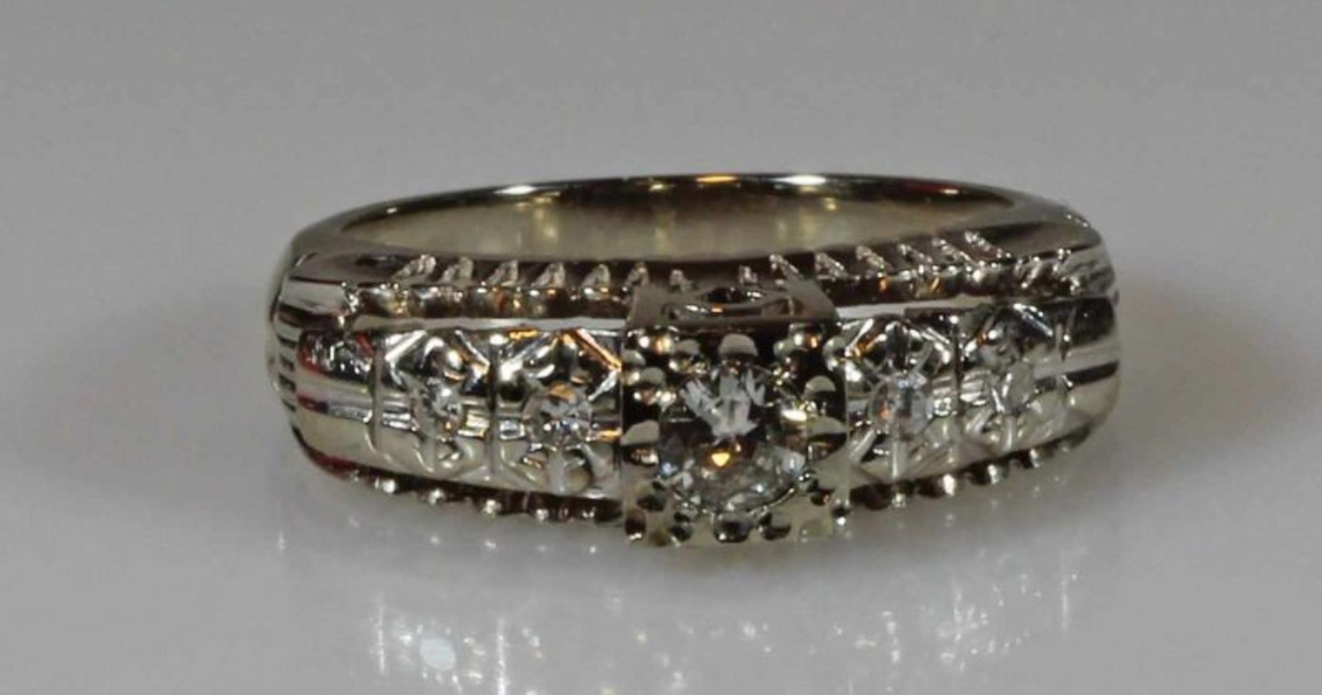 Ring, WG 750, 1 Brillant ca. 0.15 ct., 4 kleine Besatz-Diamanten, 3 g, RM 16 20.00 % buyer's premium