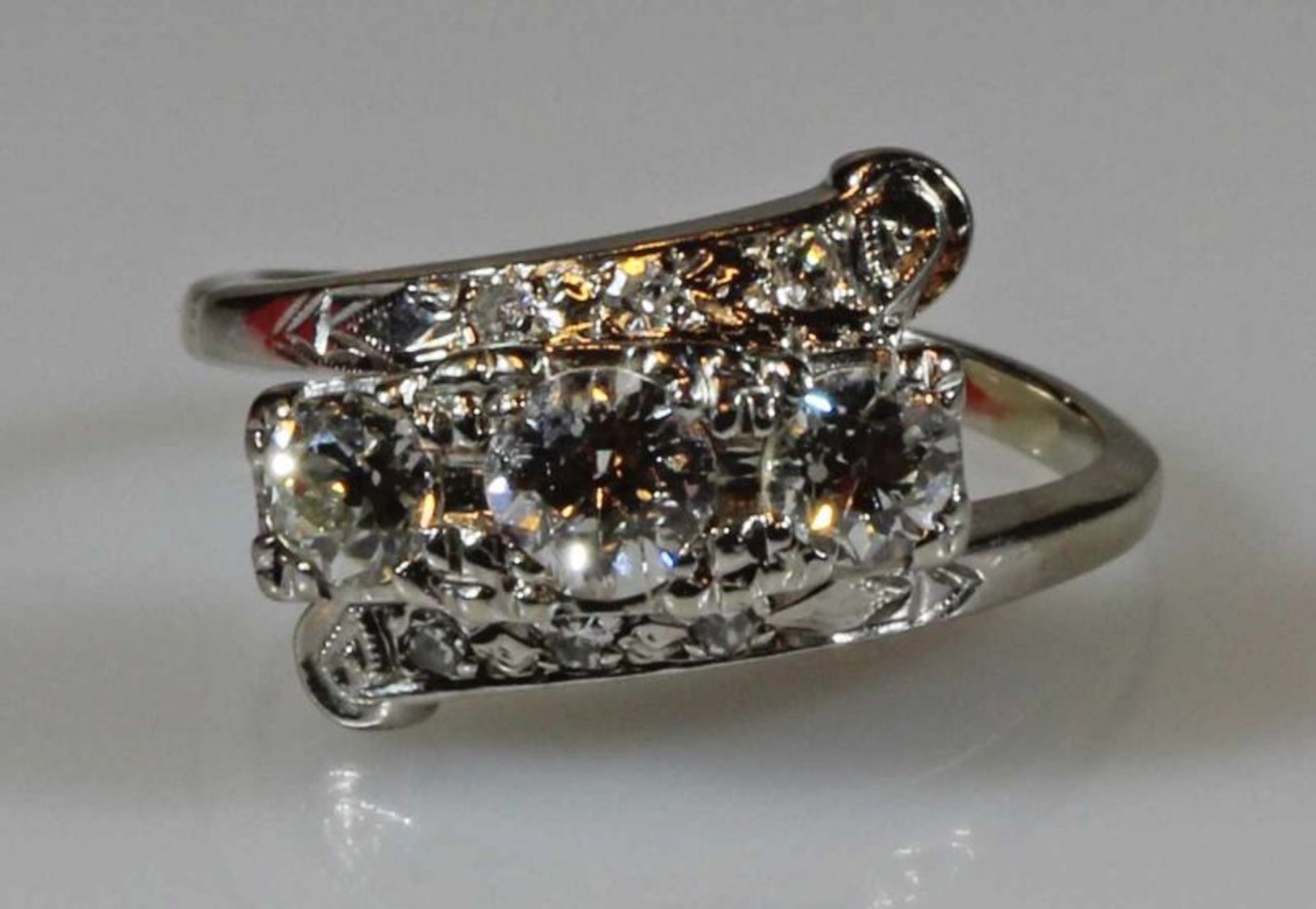 Ring, WG 585, 3 Brillanten zus. ca. 0.65 ct., 6 kleine Besatz-Diamanten, 4 g, RM 18 20.00 % buyer'