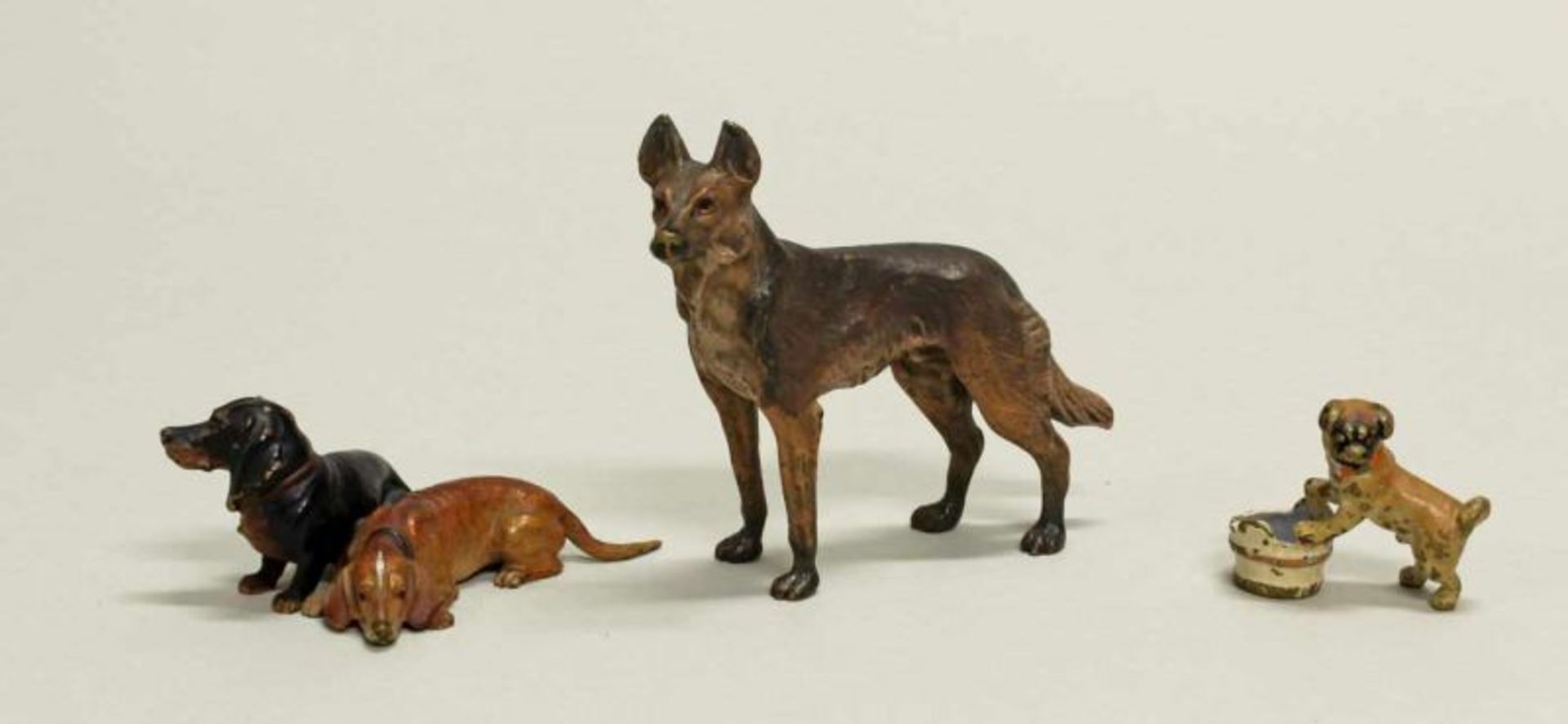 3 Miniaturfiguren, "Hunde", Wiener Bronze, polychrom, 2.8-6.8 cm hoch, teils etwas Farbverlust 20.00